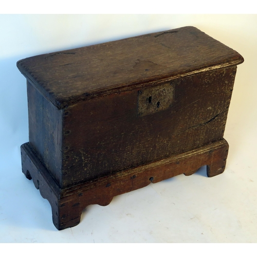 1579 - An 18th century small coffer, with rectangular hinged top, and plain sides on plinth base with brack... 