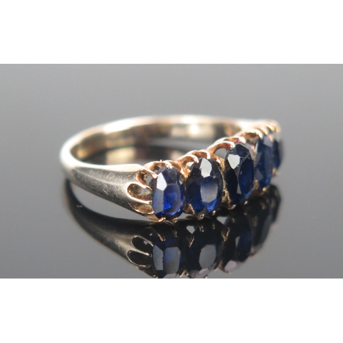 16 - A Graduated Sapphire Five Stone Ring in a precious yellow metal setting, c. 6.6x4.5mm principal ston... 