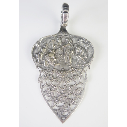 523 - A continental silver slice, with pierced blade and cartouche decorated with a tavern scene, 13cm lon... 