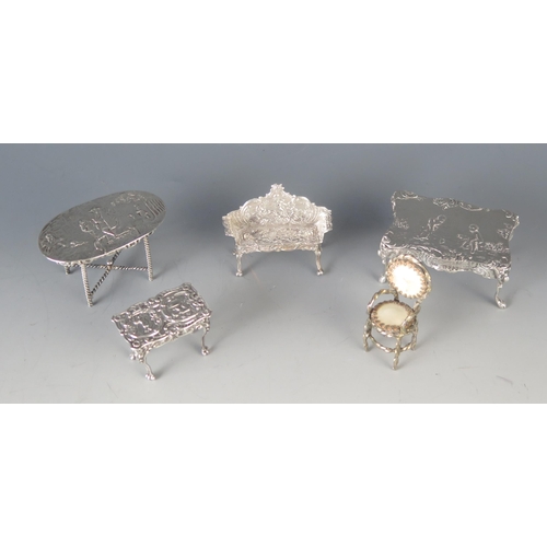 570 - Three miniature silver tables, a miniature side table and a chair, weighable silver  81gms, 2.59ozs