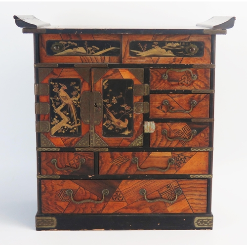 1028 - A Japanese parquetry and lacquered kodansu, with an arrangement of long and short drawers and cupboa... 