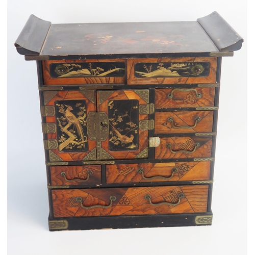 1028 - A Japanese parquetry and lacquered kodansu, with an arrangement of long and short drawers and cupboa... 