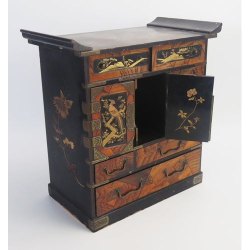 1028 - A Japanese parquetry and lacquered kodansu, with an arrangement of long and short drawers and cupboa... 