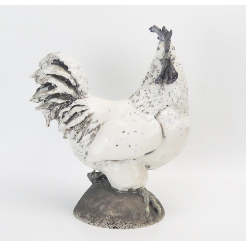 1049 - A large Raku cockerel, raised on a dome base, 29cm high.