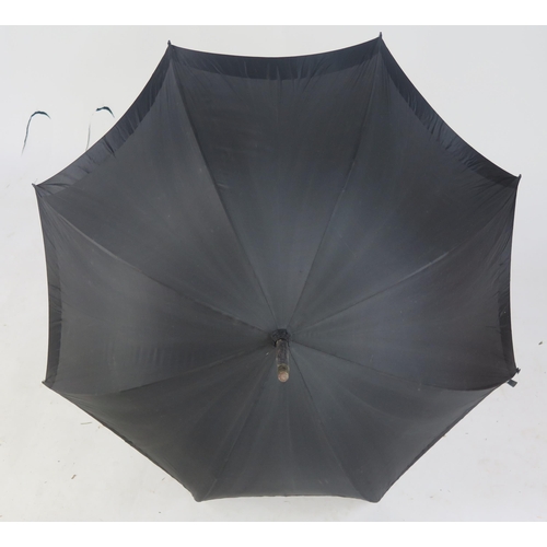 1062 - A late Victorian parasol by Paragon Ltd, with black silk canopy, the handle in the form of a cats he... 