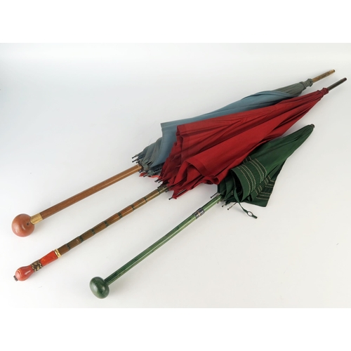 1062A - S Fox & CO, an early 20th century parasol with wine red silk canopy, together with two other parasol... 