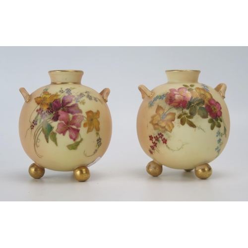 1147 - A pair of Royal Worcester blush ivory miniature vases, of ovoid form, with loop handles to the sides... 