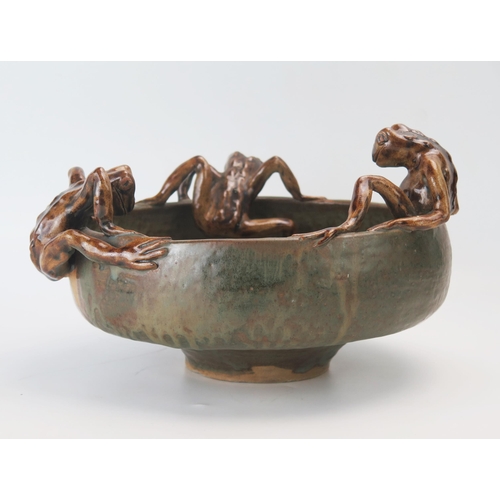 1148 - A large pottery fruit bowl of circular form decorated with three toads holding on to the rim, impres... 