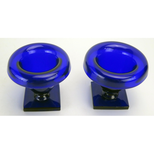 1290 - A pair of Bristol blue glass pedestal salts, of urn-shaped outline on square bases, 8cm high.