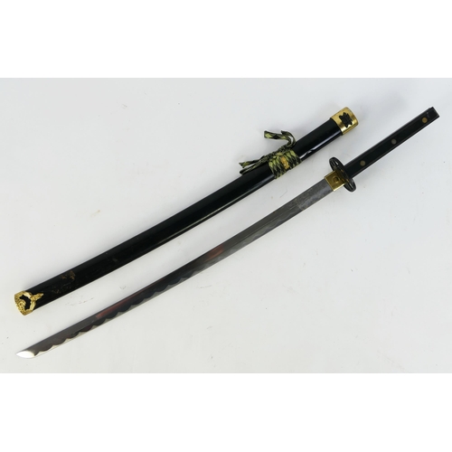 1319 - A reproduction Japanese katana, with 66cm blade, pierced and gilded alloy tsuba, and wood grip conta... 