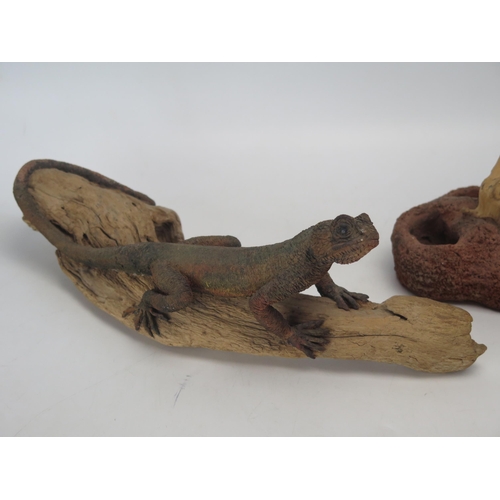 1390 - A model of a pottery lizard posed on a wood twig, together with another mounted on a stick. (2).