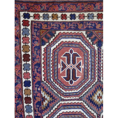 1397 - A Caucasian rug, the ivory field with four serrated lozenge medallions, enclosed by a triple geometr... 