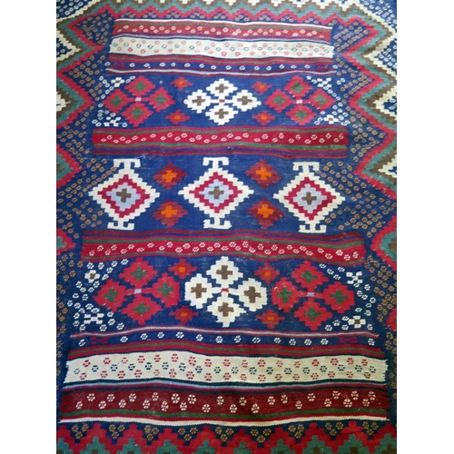 1399 - A Qashqai kelim flatweave rug, the main indigo field with three rows of stepped medallions, enclosed... 