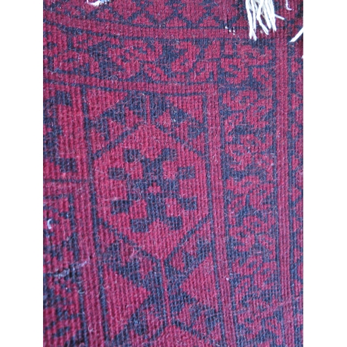 1406 - A Hamadan rug, the wine red field with two rows of hooked medallions, enclosed by a multiple geometr... 