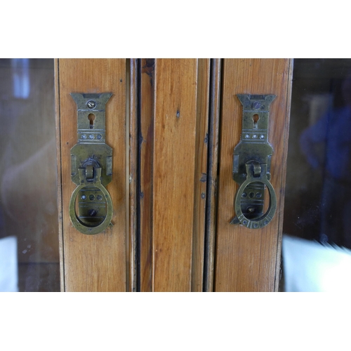 1431 - A Victorian pine dresser. the upper part with a pair of arched glazed panelled doors, the base conta... 