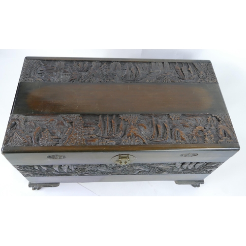 1435 - A Southeast Asian carved camphor wood chest of rectangular form, the hinged lid decorated with coast... 