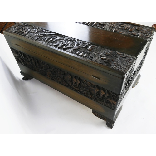 1435 - A Southeast Asian carved camphor wood chest of rectangular form, the hinged lid decorated with coast... 