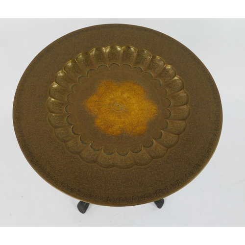 1441 - A middle eastern brass top circular table, with lobed decoration, on a folding tripod base, 69cm dia... 