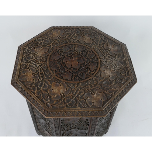 1442 - An eastern carved hardwood folding octagonal occasional table, the top decorated with foliage and fl... 