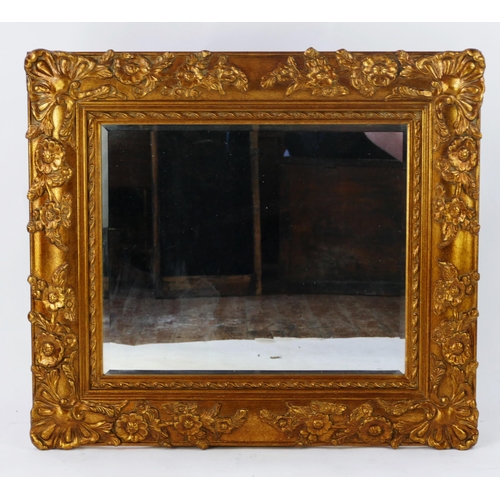 1447 - A gilt wall mirror with moulded floral decoration enclosing a rectangular mirror plate, 77 x 85cm