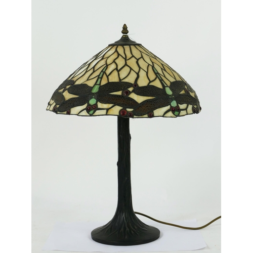 1070 - A Tiffany style table lamp in the Art Nouveau style, the domed shade decorated with dragonflies, on ... 