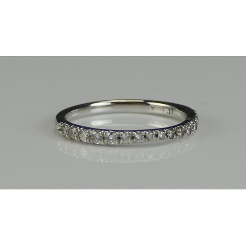 144 - An 18ct White Gold and Diamond Band set with sixteen c. 1.4mm brilliant round cuts, size G, 1.43g