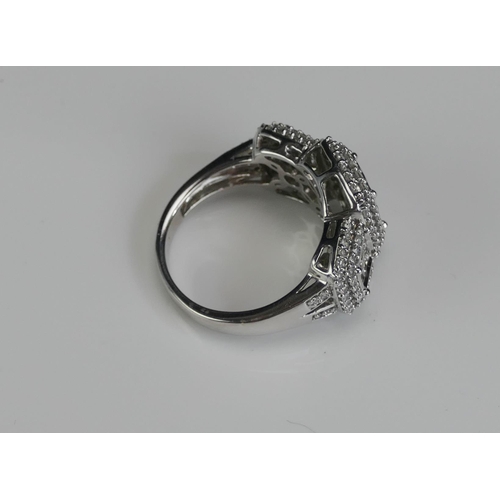 265 - An 18ct White Gold and Diamond Panel Ring, the central elements invisibly set princess cuts and enve... 