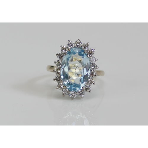 66 - An 18ct White Gold, Aqua Marine and Diamond Oval Cluster Ring, 13.8x9.3mm principal stone surrounded... 