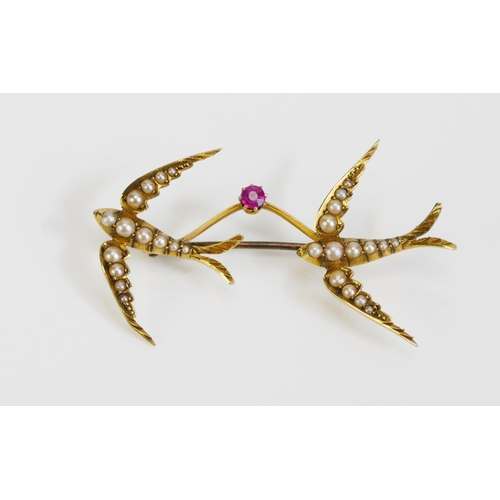 67 - A Ruby and Seed Pearl Twin Swallow Brooch in a precious yellow metal setting, c. 49.3mm wide, KEE te... 