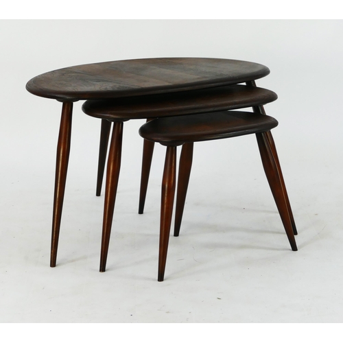 1455 - A nest of three Ercol beech and elm pebble occasional tables, raised on turned legs. (3).