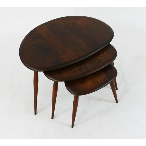 1455 - A nest of three Ercol beech and elm pebble occasional tables, raised on turned legs. (3).