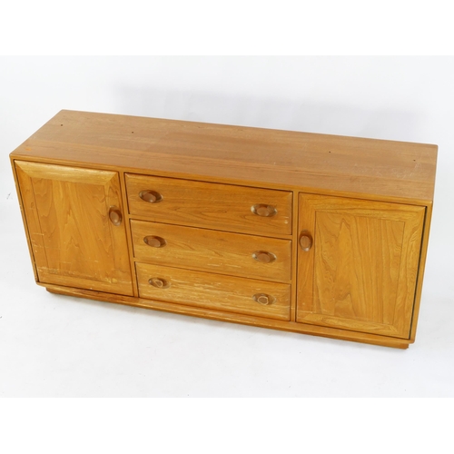 1464 - An elm and beech Ercol sideboard, containing three central drawers flanked by cupboard doors, on a p... 