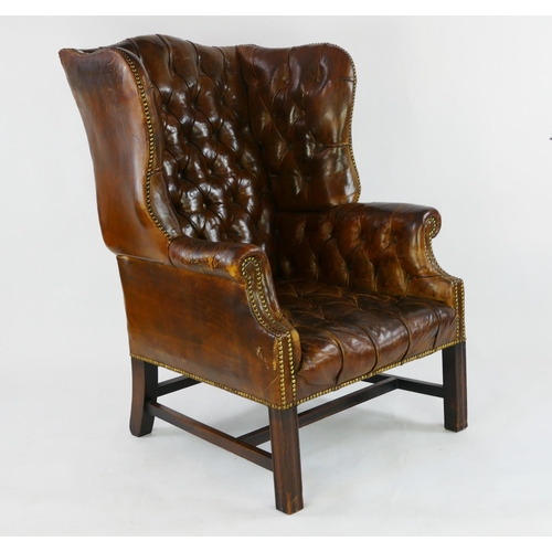 1493 - A fully upholstered leather wing back club chair, with button-down back, arm rests and cushion, rais... 