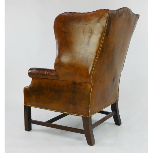 1493 - A fully upholstered leather wing back club chair, with button-down back, arm rests and cushion, rais... 