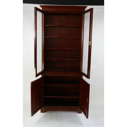 1494 - A Victorian mahogany bookcase, the upper part with a pair of glazed panelled doors enclosing shelvin... 