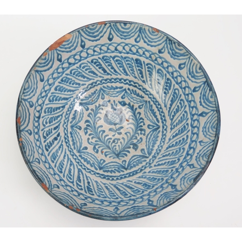 1522 - A Spanish pottery fruit bowl, with banded blue scroll and foliate decoration 26.5cm diameter,