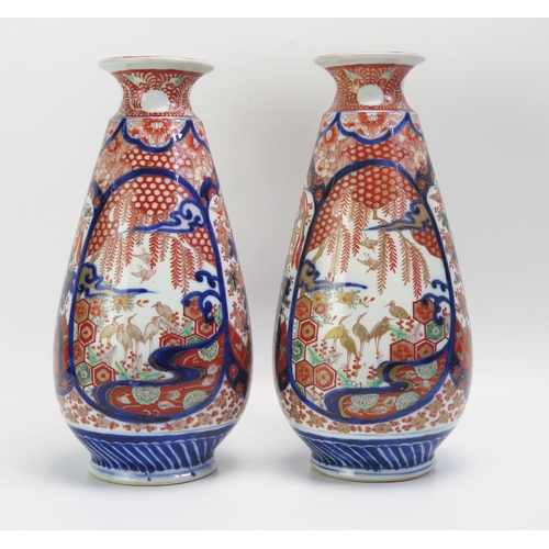 1531 - A pair of Imari porcelain vases of ovoid form, with panels of exotic birds and foliage, in tradition... 