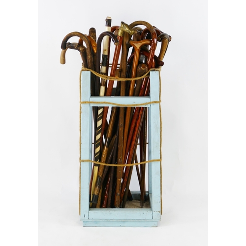 1553 - A collection of assorted bentwood and other walking sticks contained in an oak stick stand.