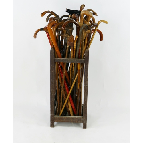 1554 - A collection of assorted bentwood and other walking sticks contained in a painted stick stand.