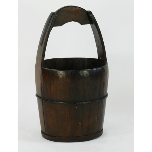 1562 - A large Chinese wooden bucket of coopered construction, with loop carrying handle with metal strap, ... 