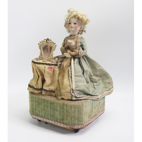 1571 - A continental bisque head doll automaton, of a seated lady at her dressing table holding a hand mirr... 