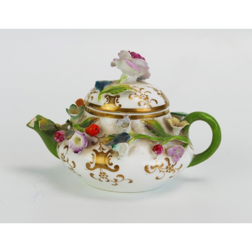 1585 - A German porcelain miniature teapot with floral encrusted decoration, 10cm long.