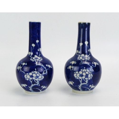 1594 - A pair of Chinese blue and white vases, of bulbous form with slender necks having prunus decoration,... 