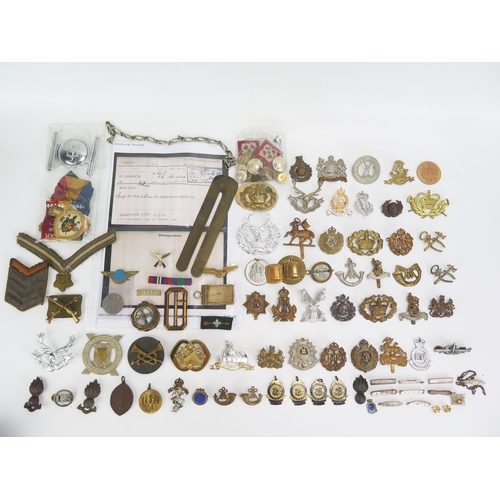 1615 - A collection of assorted military cap badges, belt buckle, cloth badges, etc.