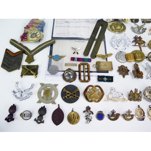 1615 - A collection of assorted military cap badges, belt buckle, cloth badges, etc.