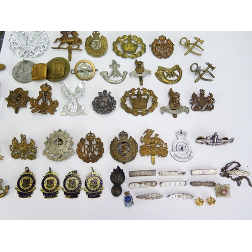 1615 - A collection of assorted military cap badges, belt buckle, cloth badges, etc.