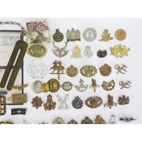 1615 - A collection of assorted military cap badges, belt buckle, cloth badges, etc.