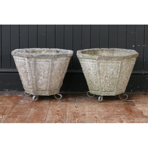 1658 - A pair of reconstituted stone urns of octagonal tapering form, with panelled decoration and raised o... 