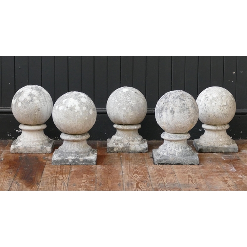 1663A - A set of five reconstituted stone ball finials, mounted on square bases, 32cm high. (5).