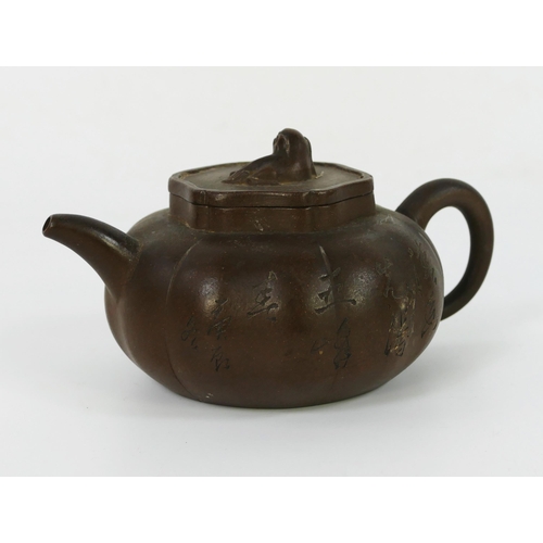 1701 - A Chinese Yixing pottery teapot and cover, of lobed circular form, with dog of Fo finial, 18cm long.